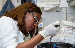 woman scientist piping a sample into a machine