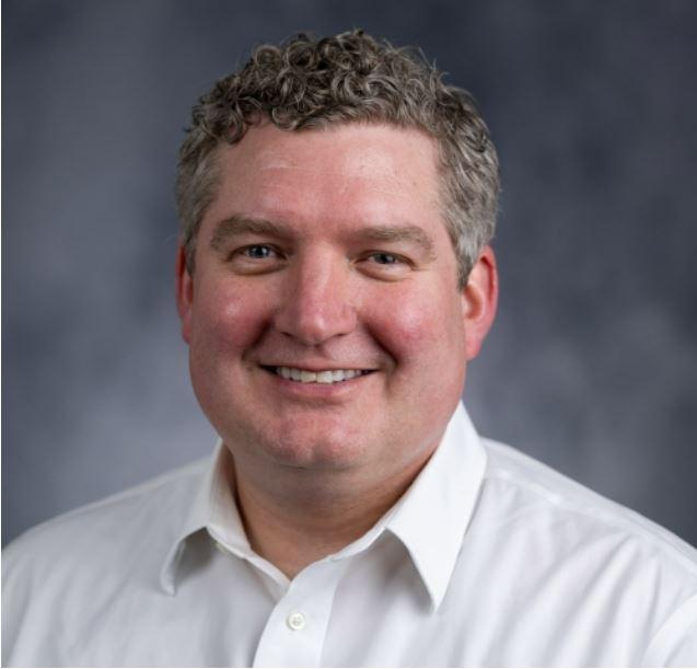 Head shot of Dr. Parker, smiling in white button up shirt