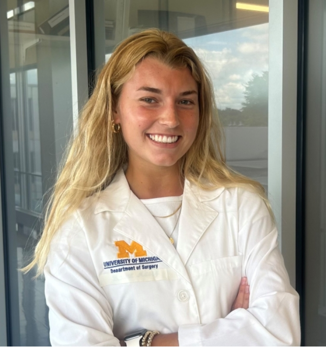 Audrey DeSchryver smiling with arms folded in a white lab coat
