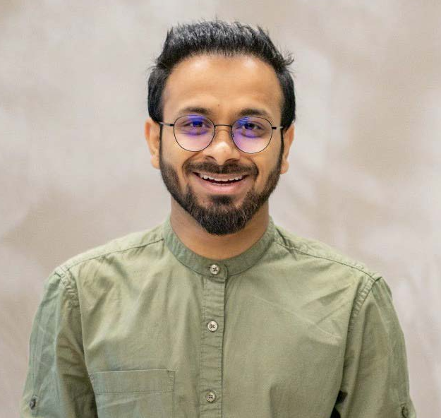 Headshot of Dr. Bandral smiling in a green short