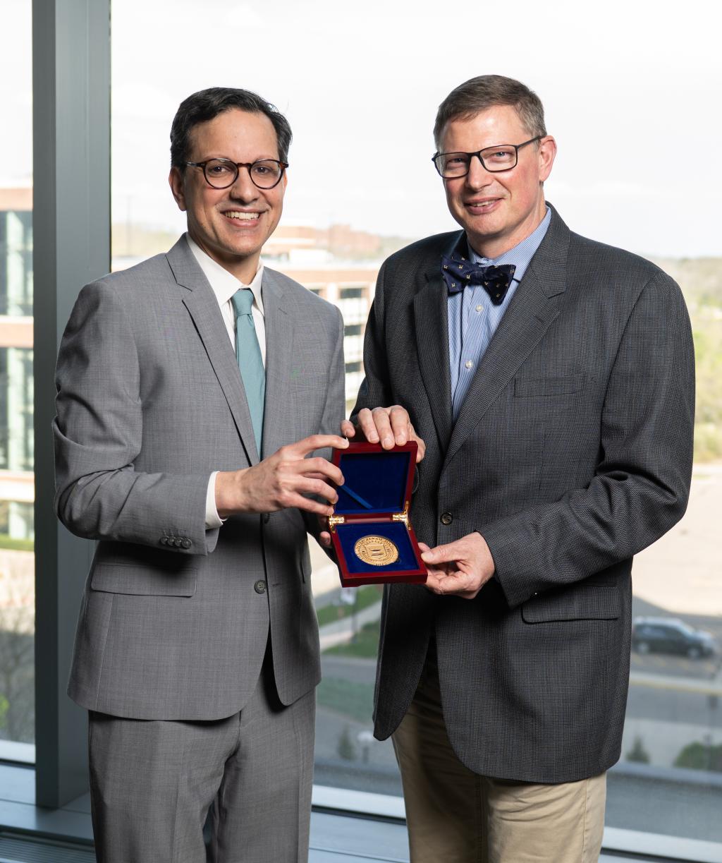 Drs. Soleimanpour and Myers standing together holding  a medal