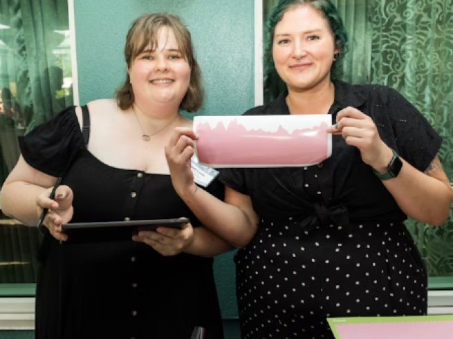 Krista and colleague holding up a glucose reading sticker